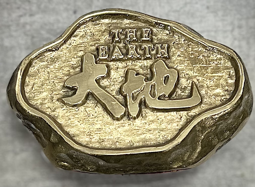 大地儀器Logo，以金色石頭雕刻呈現大地文字